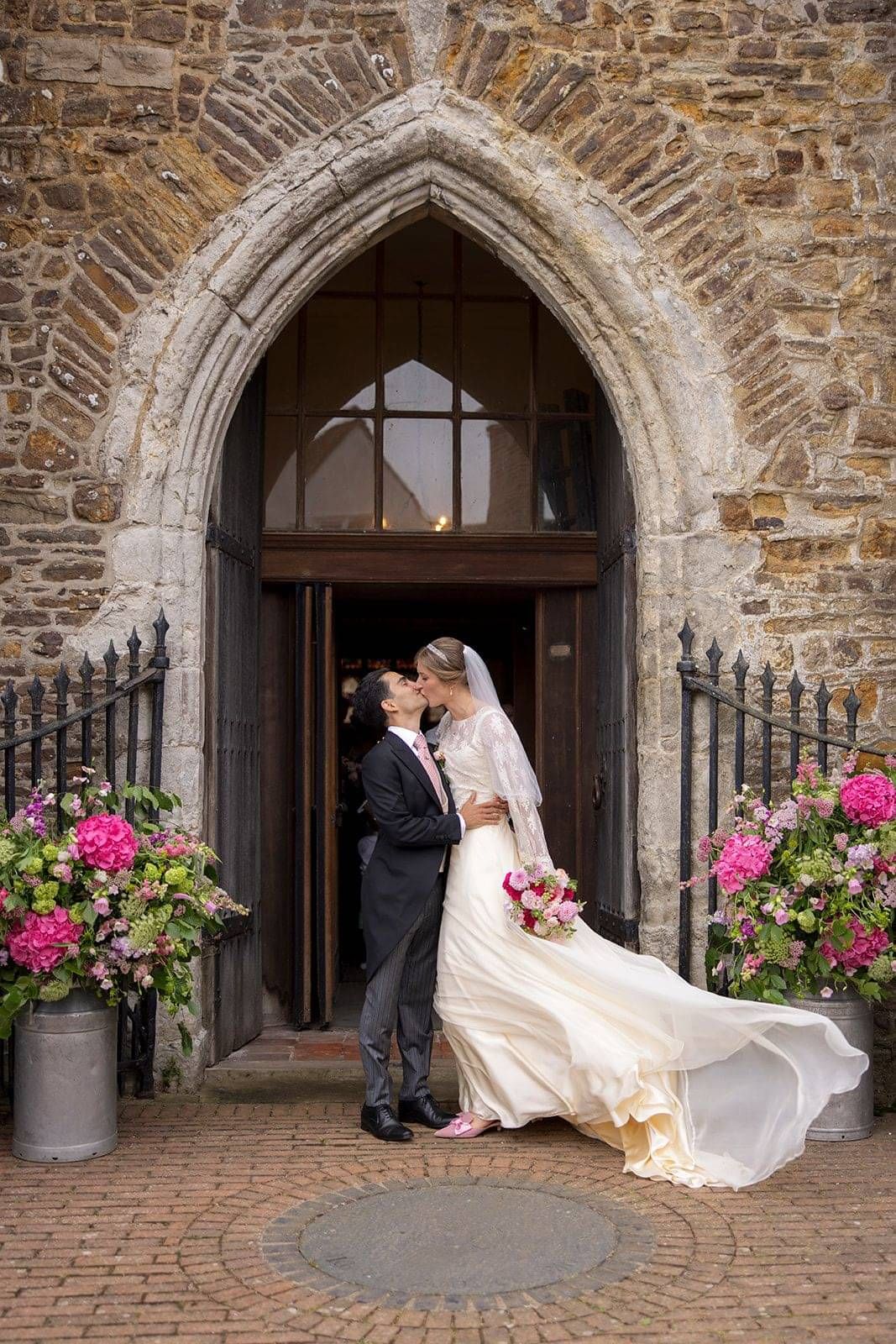 bride wearing bespoke wedding gown by Kate Edmondson, Bride outside the church after wedding ceremony, wedding dress designer near me,