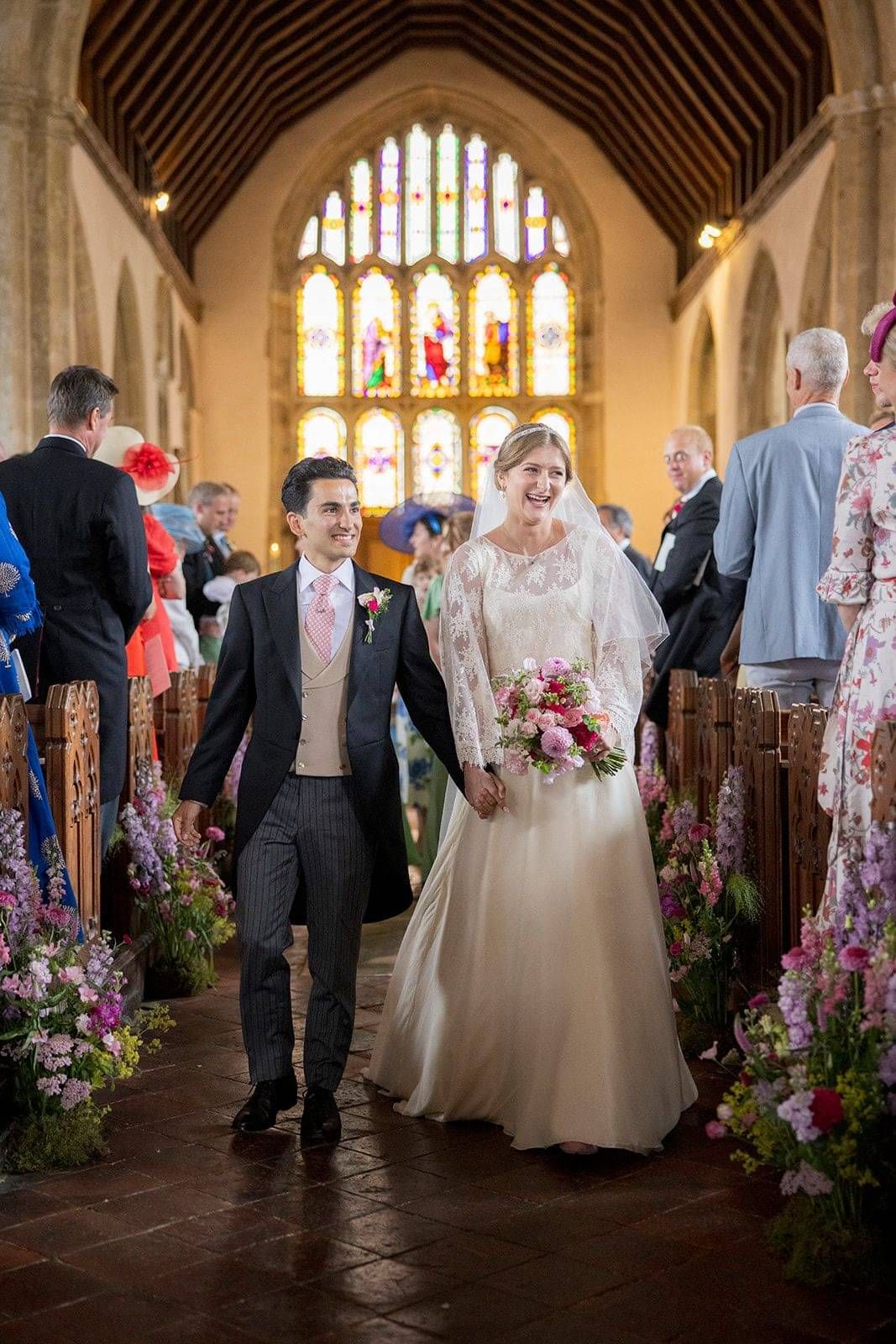 Bride and gown walk down the church aisle smiling after ceremony, Bride wearing custom made gown by Kate Edmondson