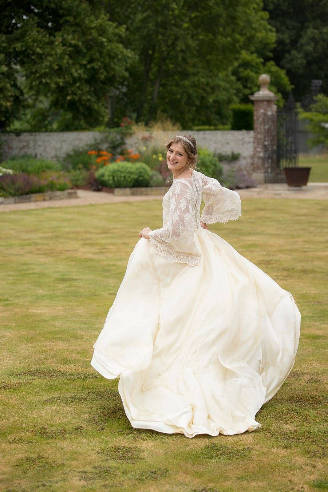 Bride wearing bespoke wedding dress and bridal top at her wedding at Hole park Gardens