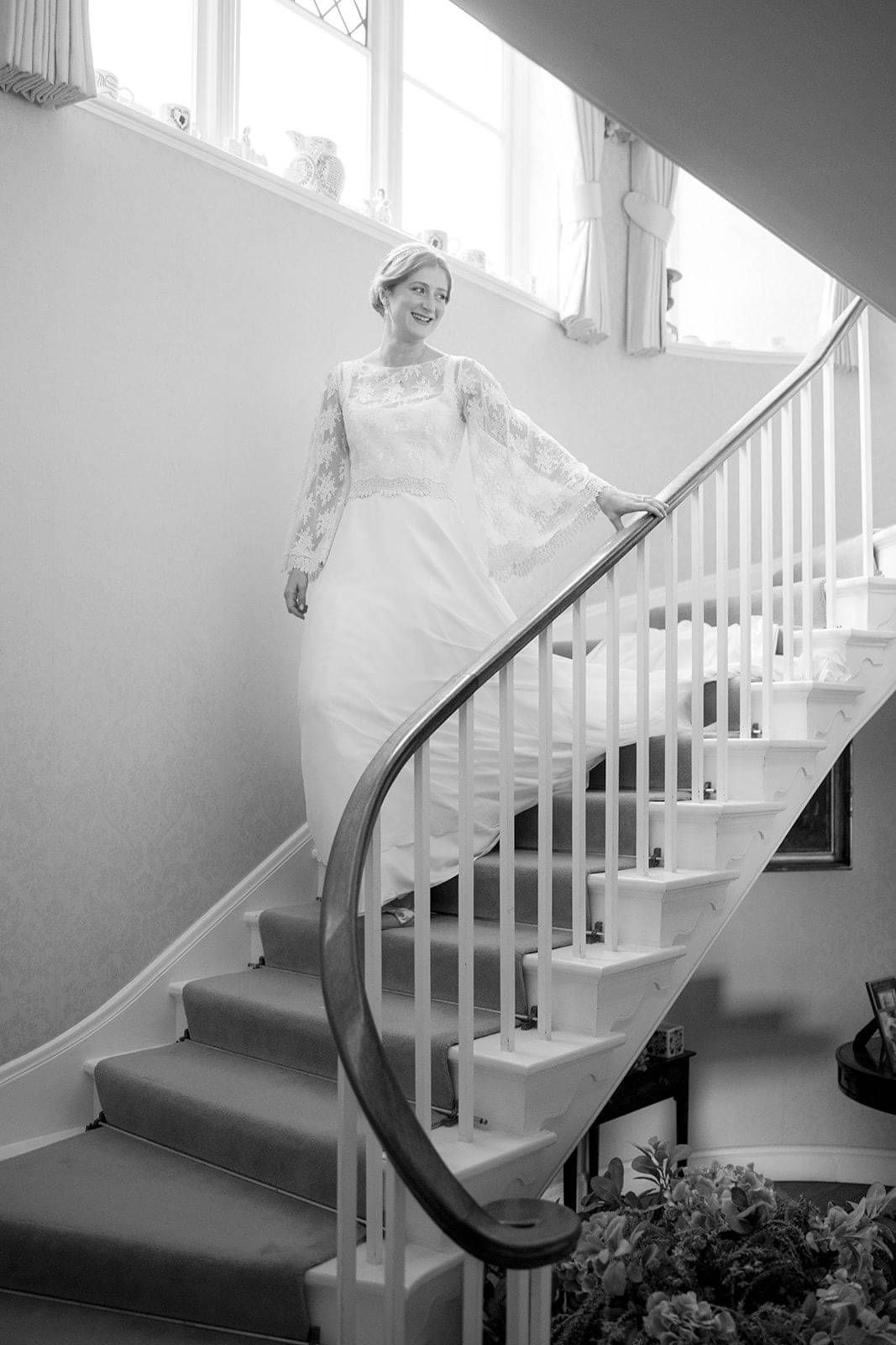 Bride stepping down the stairs wearing her vintage inspired wedding dress and bridal top at Hole Park Gardens