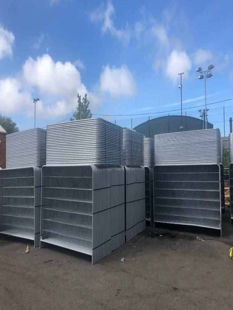 Large stack of galvanised Heras fencing panels at Tempfence UK factory yard for bulk trade orders and nationwide delivery