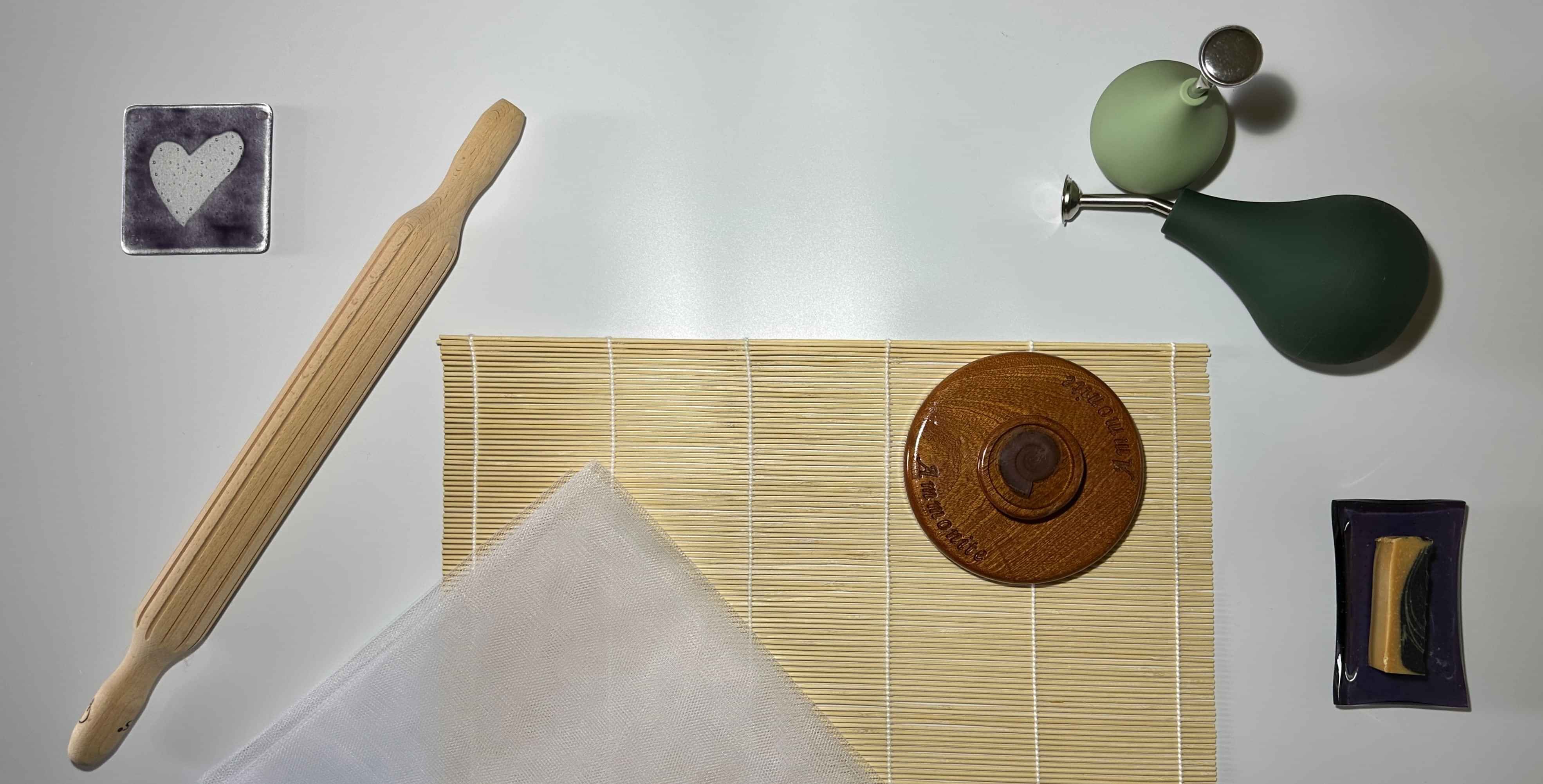 wet felting tools laid out on a white background, with a purple coaster with the heart logo motif